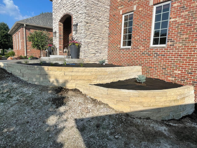 large tiered scalloped retaining walls in front of home