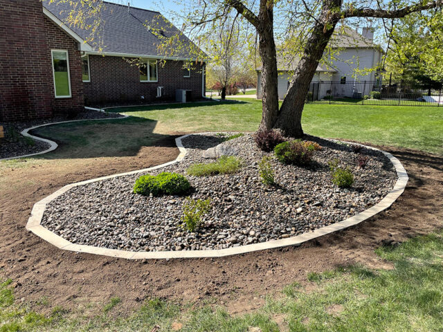 brick border river rock garden area surrounding tree