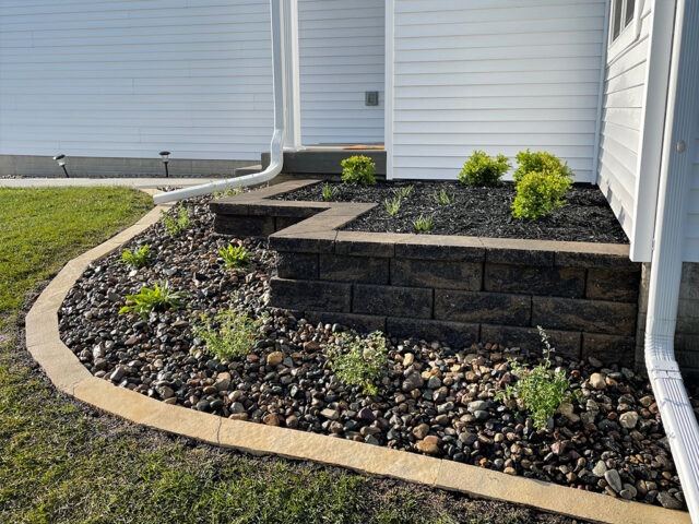 raised brick garden with river rock and brick border area