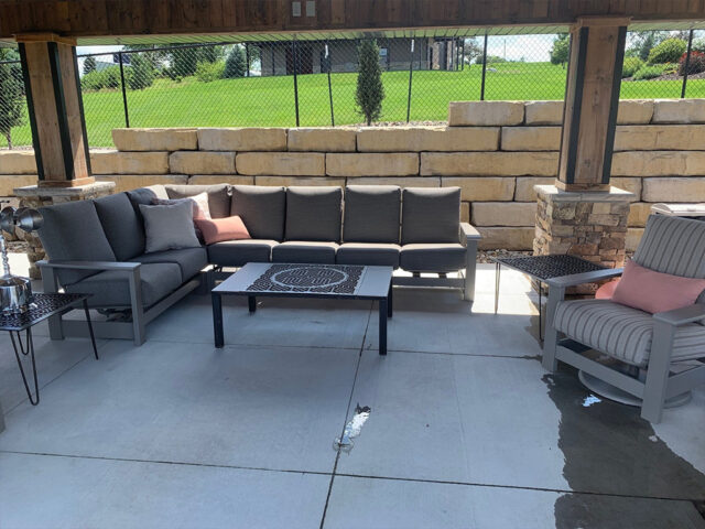 large retaining wall with huge stone brick behind brick and wood gazebo
