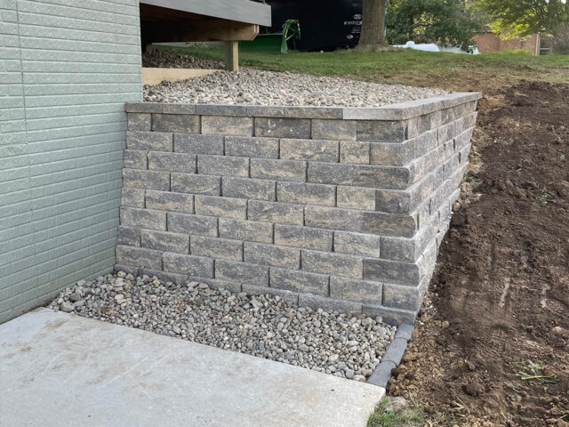 large brick retaining wall with river rock