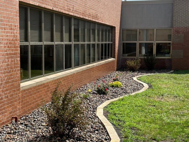 garden area with rock and stone border by school building