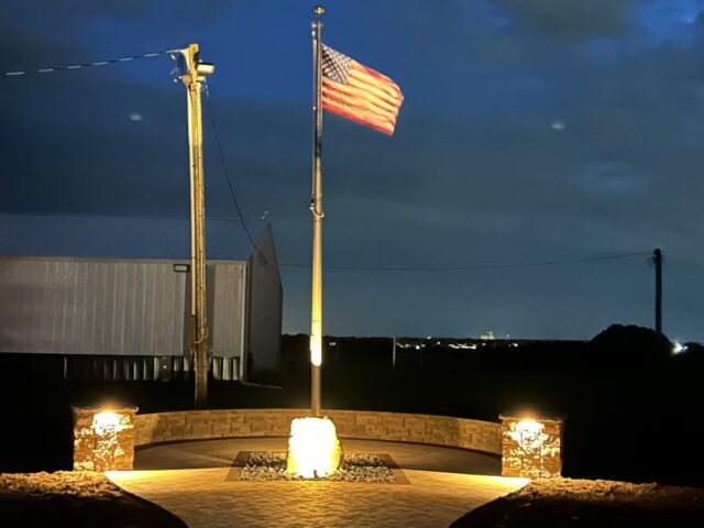 brick tile pathway to semicircle brick landscape flagpole area